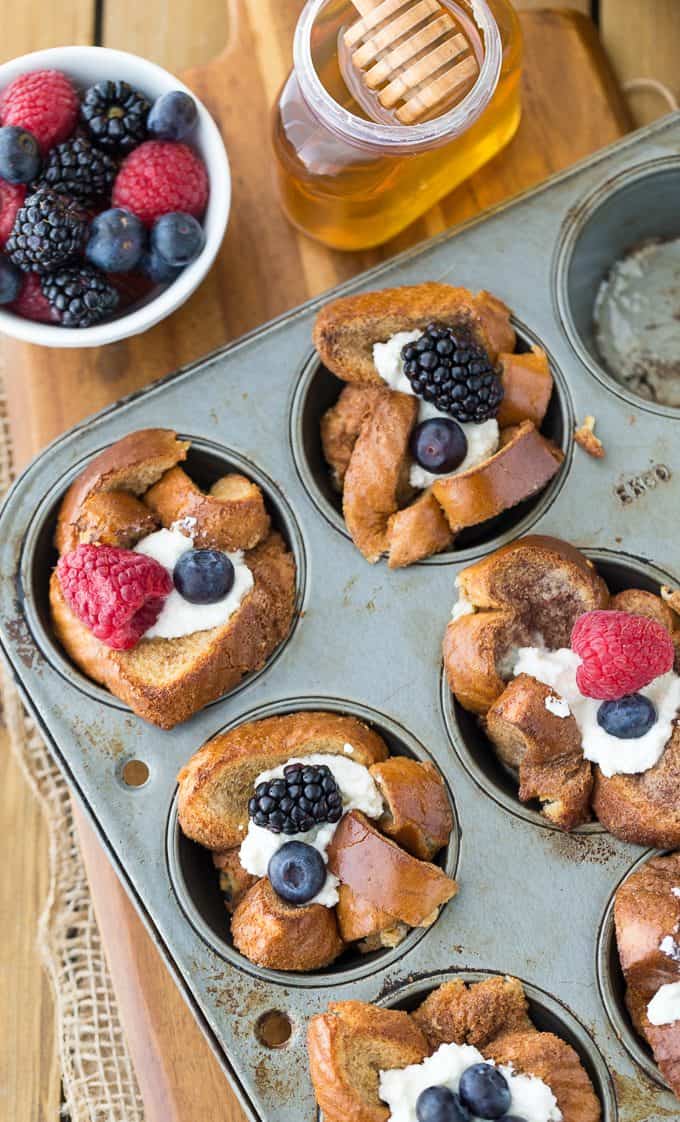 Honey Almond Breakfast Cups - Even the picky eaters loved this easy weekend breakfast recipe! French toast cups are filled with a sweet, creamy ricotta filling and topped with honey, berries and slivered almonds.
