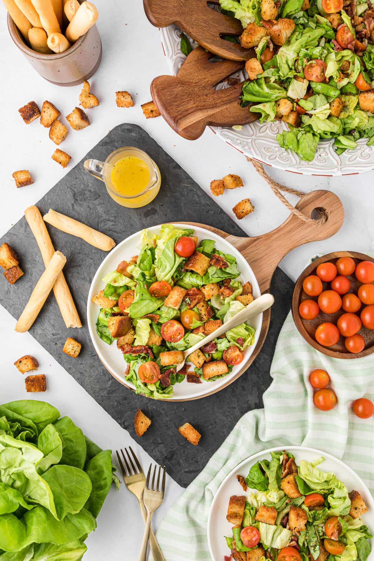 BLT Salad o a plate surrounded by ingredients.