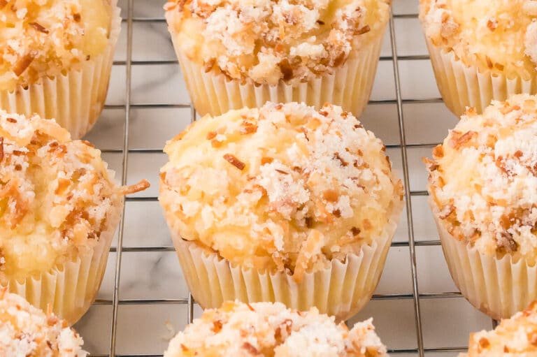 Toasted coconut muffins on a wire rack.