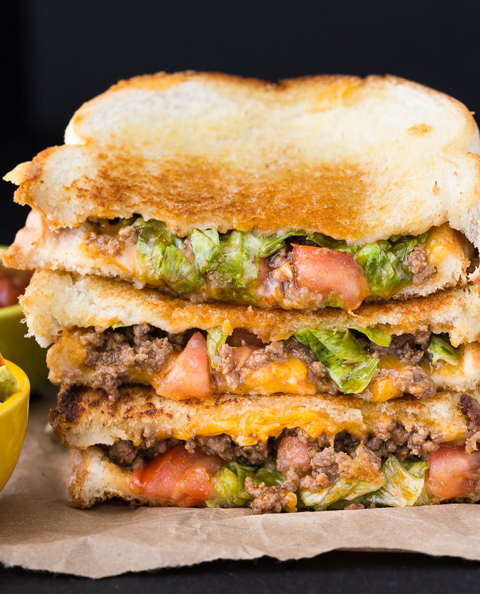 Taco Grilled Cheese Sandwich - Spice up your soup night! This crunchy sandwich is stuffed with seasoned ground beef, lettuce, tomatoes, and gooey cheese for the most filling grilled cheese recipe.