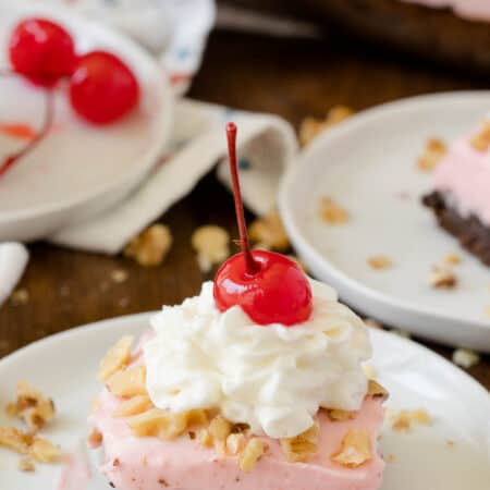 A slice of a banana split brownie on a white plate