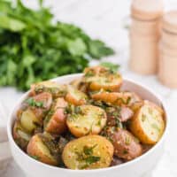 Herb potato salad in a white bowl.