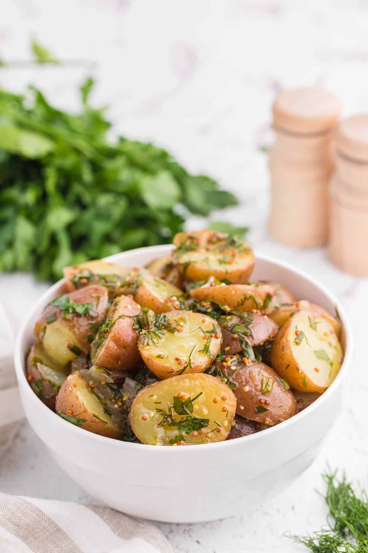 Herb potato salad in a white bowl.