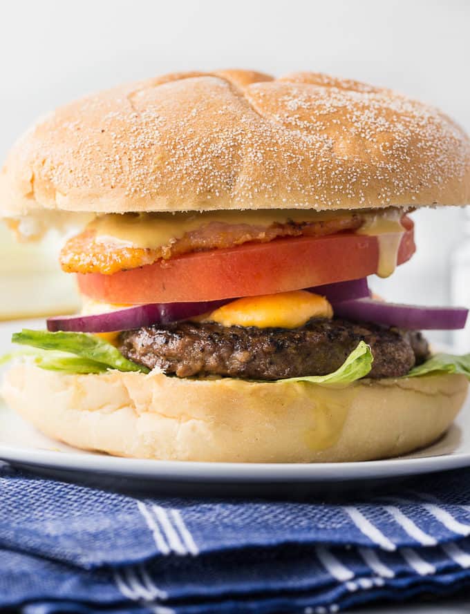 Ultimate Ontario Burger - A juicy burger topped with melted cheddar cheese curds, Maple Mustard, Peameal bacon and fresh local veggies. 