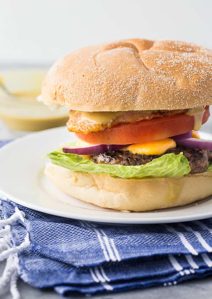 Ultimate Ontario Burger - A juicy burger topped with melted cheddar cheese curds, Maple Mustard, Peameal bacon and fresh local veggies. 