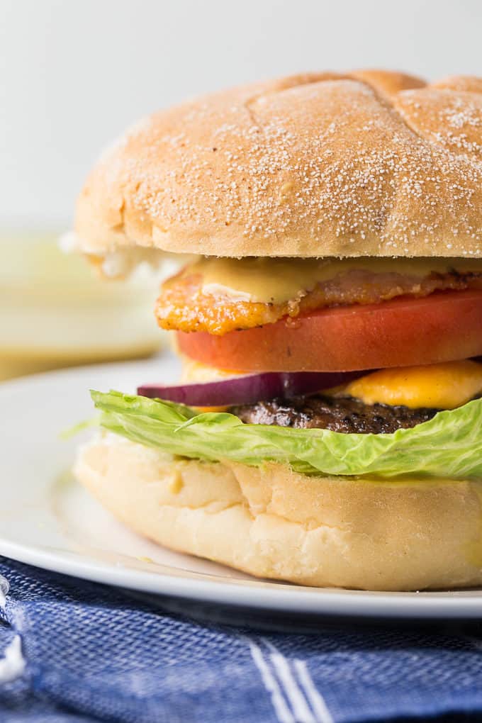 Ultimate Ontario Burger - A juicy burger topped with melted cheddar cheese curds, Maple Mustard, Peameal bacon and fresh local veggies. 