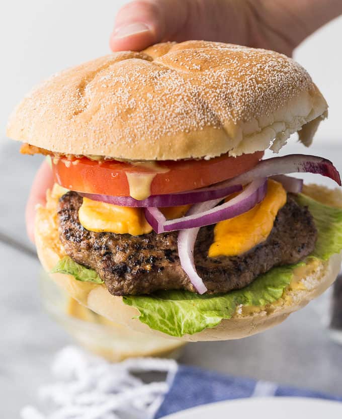 Ultimate Ontario Burger - A juicy burger topped with melted cheddar cheese curds, Maple Mustard, Peameal bacon and fresh local veggies. 