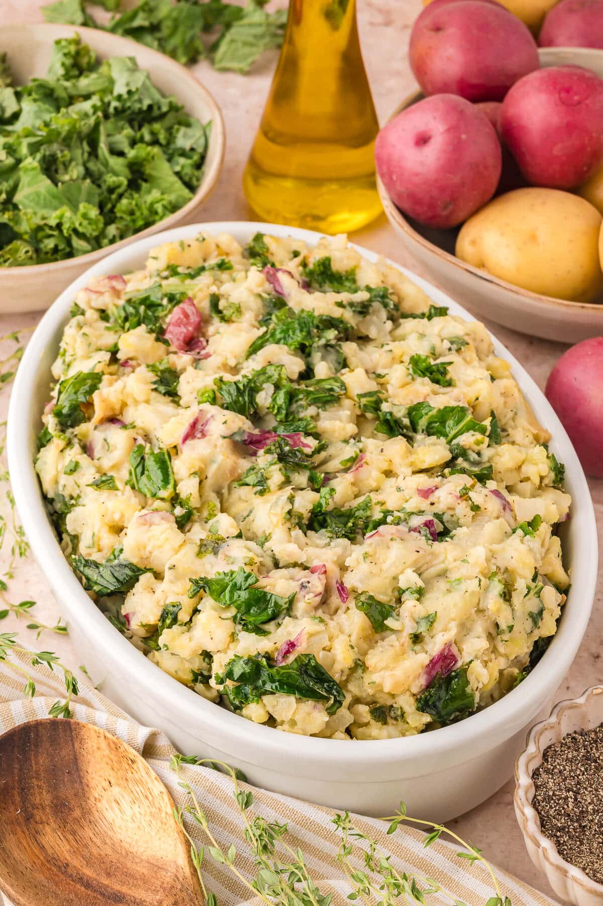 Olive oil mashed potatoes with kale and herbs on a table.