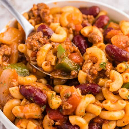 Chili macaroni in a white bowl with a spoon.
