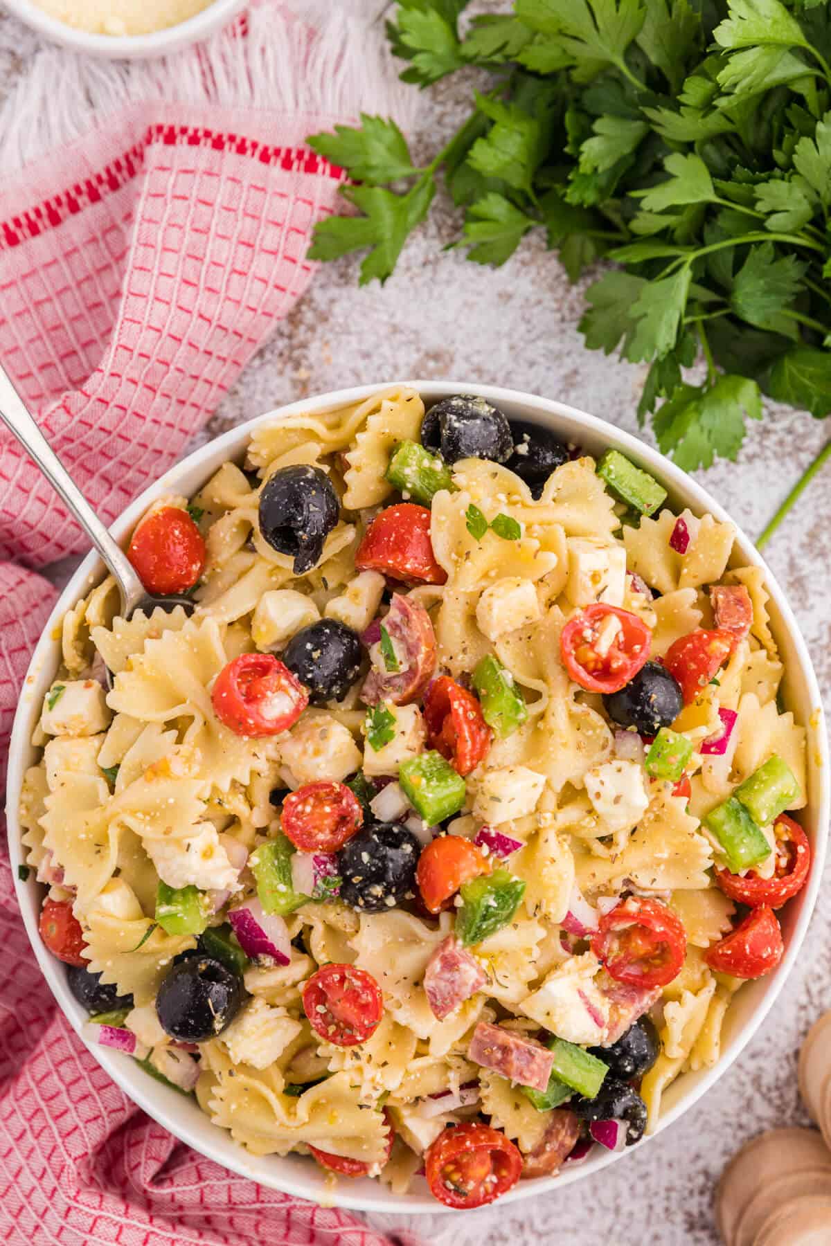 Italian pasta salad in a bowl with a spoon.