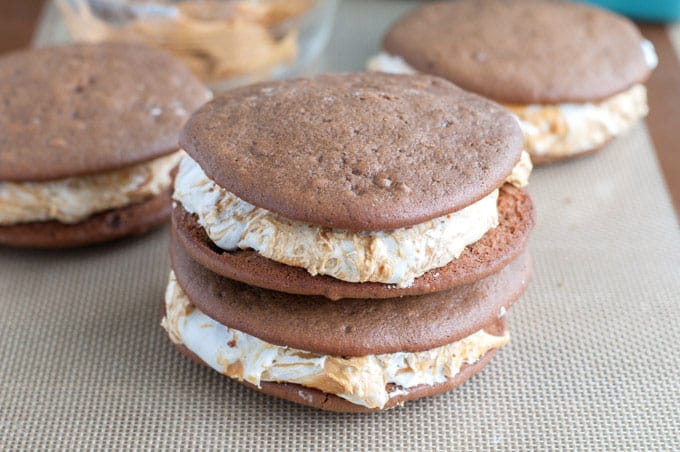 Chocolate Peanut Butter Whoopie Pies - A dessert lover's dream! Marshmallow fluff swirled with peanut butter sandwiched between two soft chocolate cookies. 