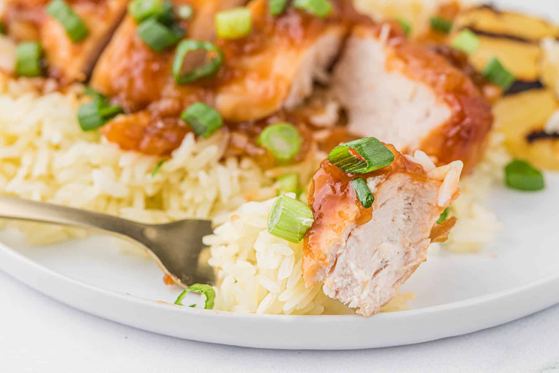 Hawaiian chicken on a fork on a plate.