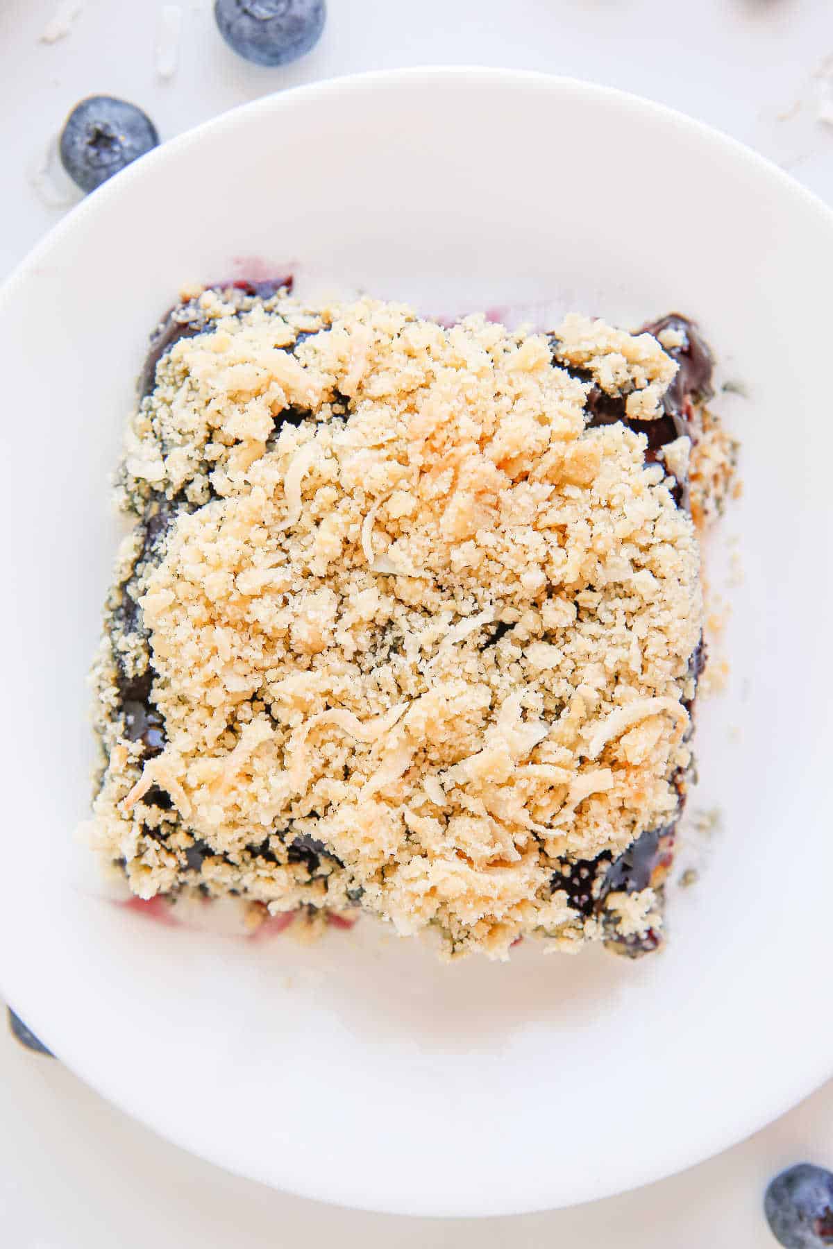 A piece of blueberry crackle cake on a plate.