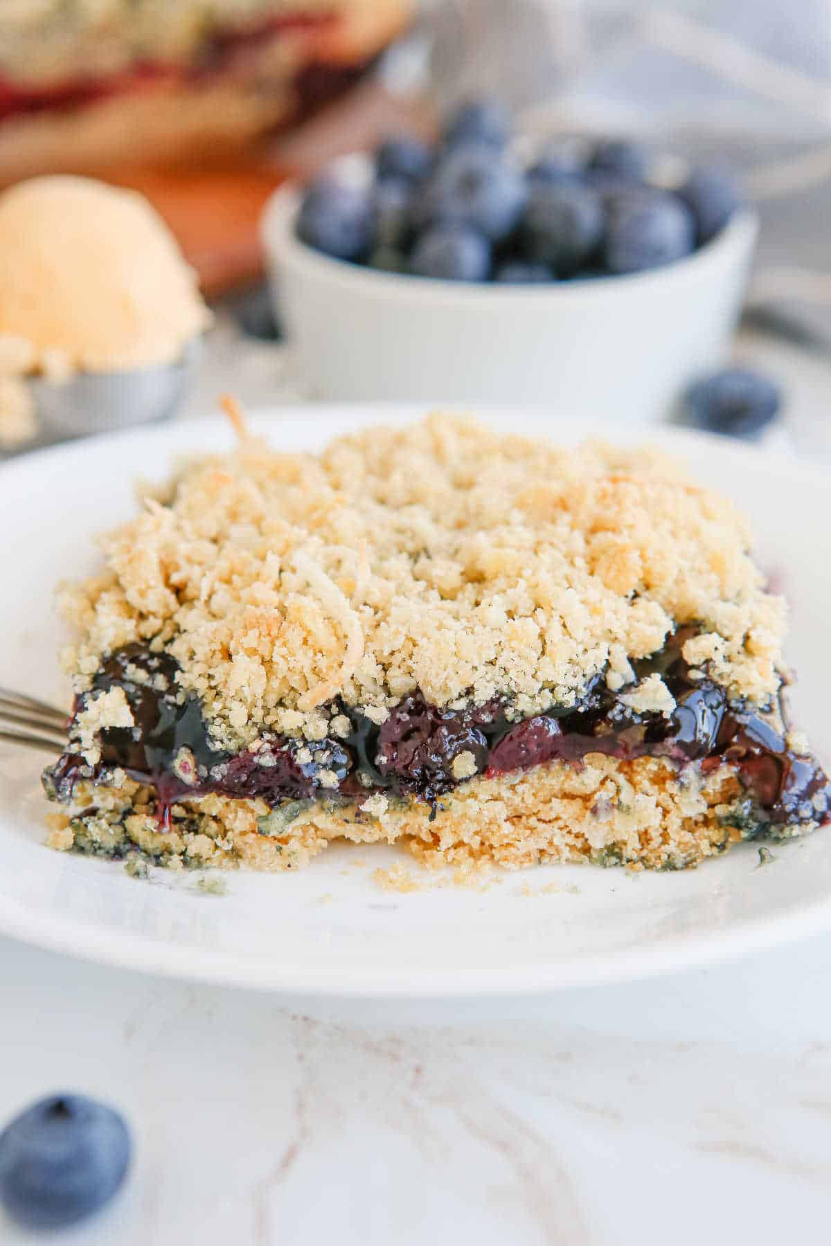 A piece of blueberry crackle cake on a plate.