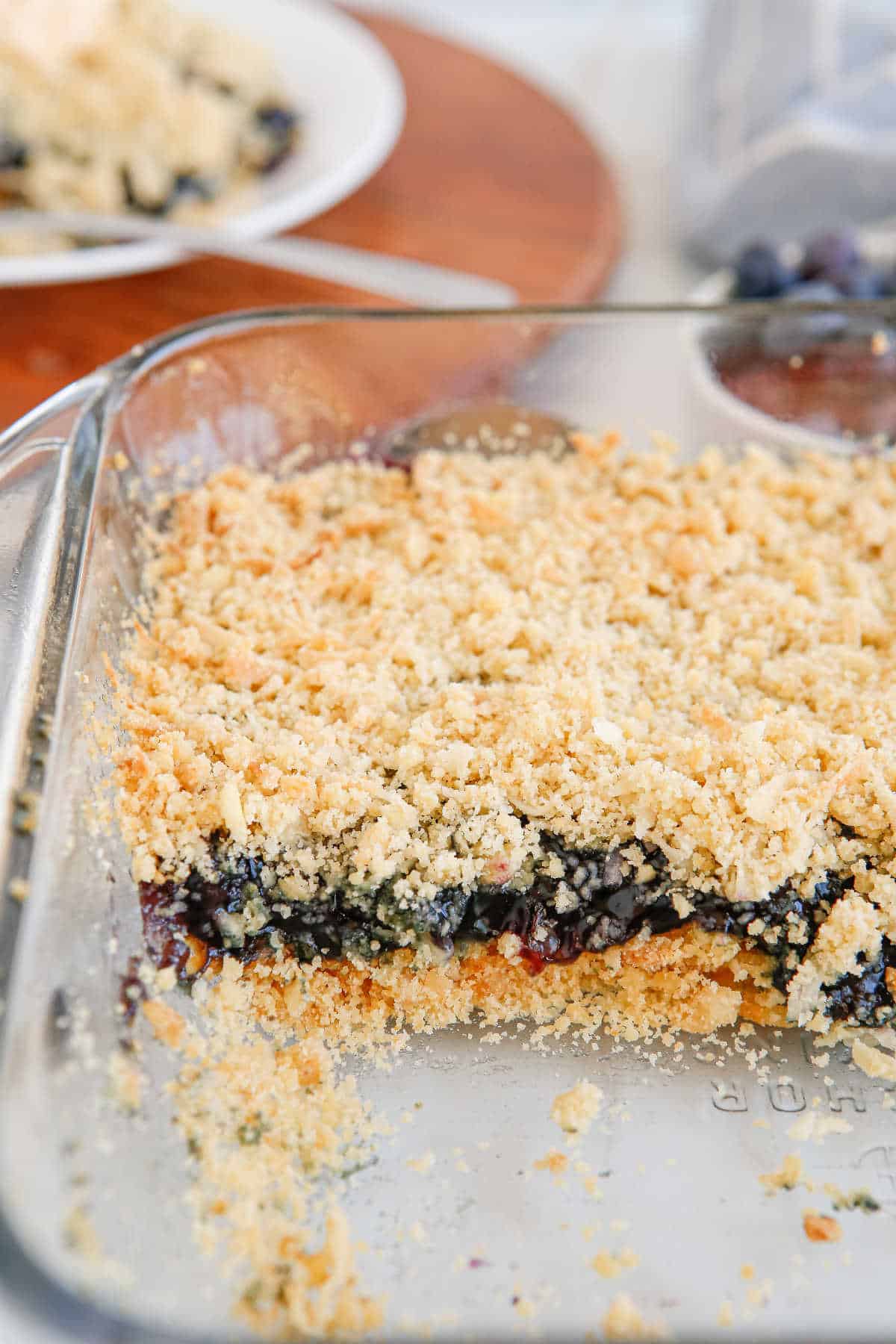 A pan of blueberry crackle cake with pieces missing out of it.