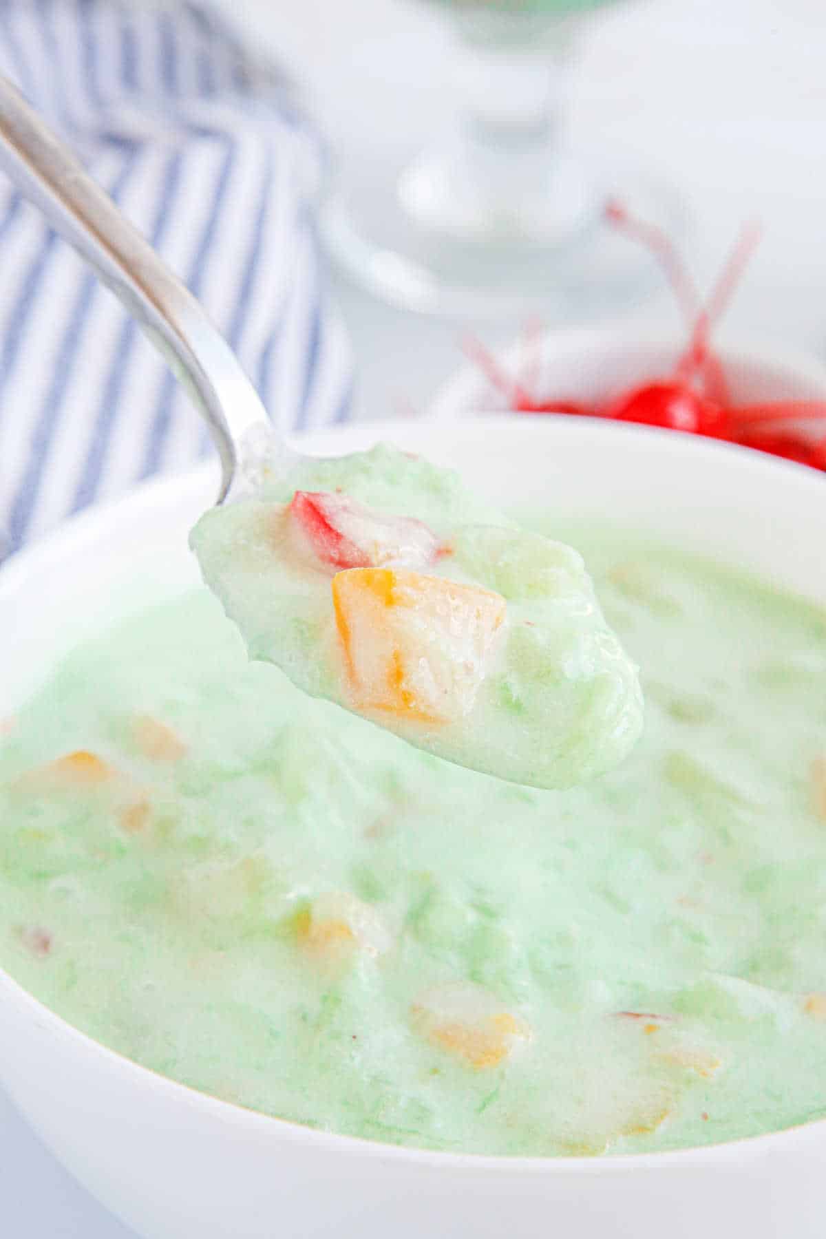 Fruit cocktail dessert on a spoon.