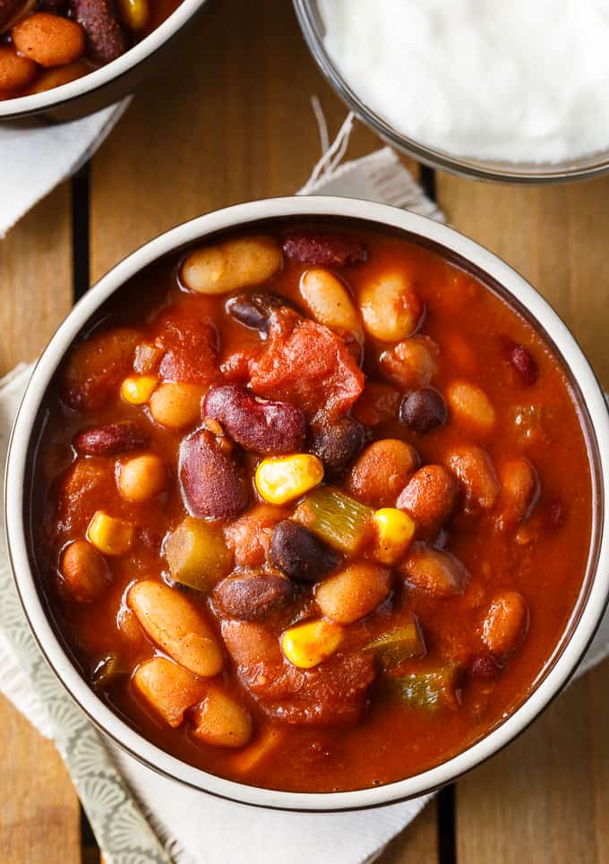 Bean Chili - The heartiest meat-free chili recipe! Use four different kinds of canned beans in this comfort food classic with peppers, corn, and tomatoes.