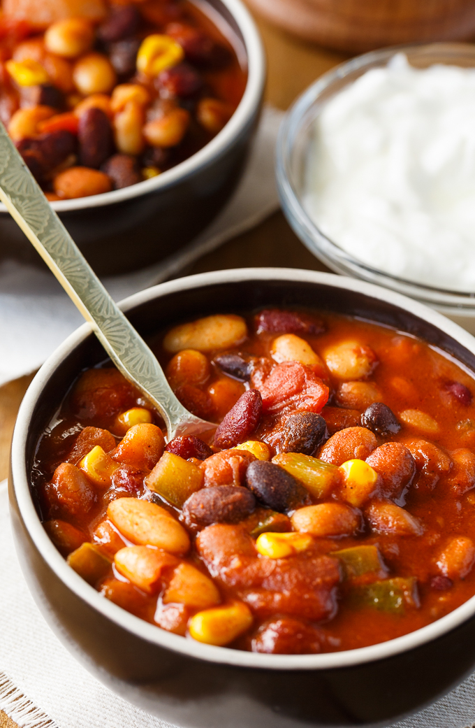 Bean Chili - The heartiest meat-free chili recipe! Use four different kinds of canned beans in this comfort food classic with peppers, corn, and tomatoes.