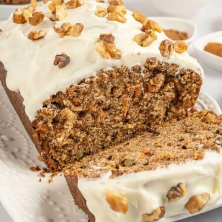A carrot cake loaf with a slice cut off the end.
