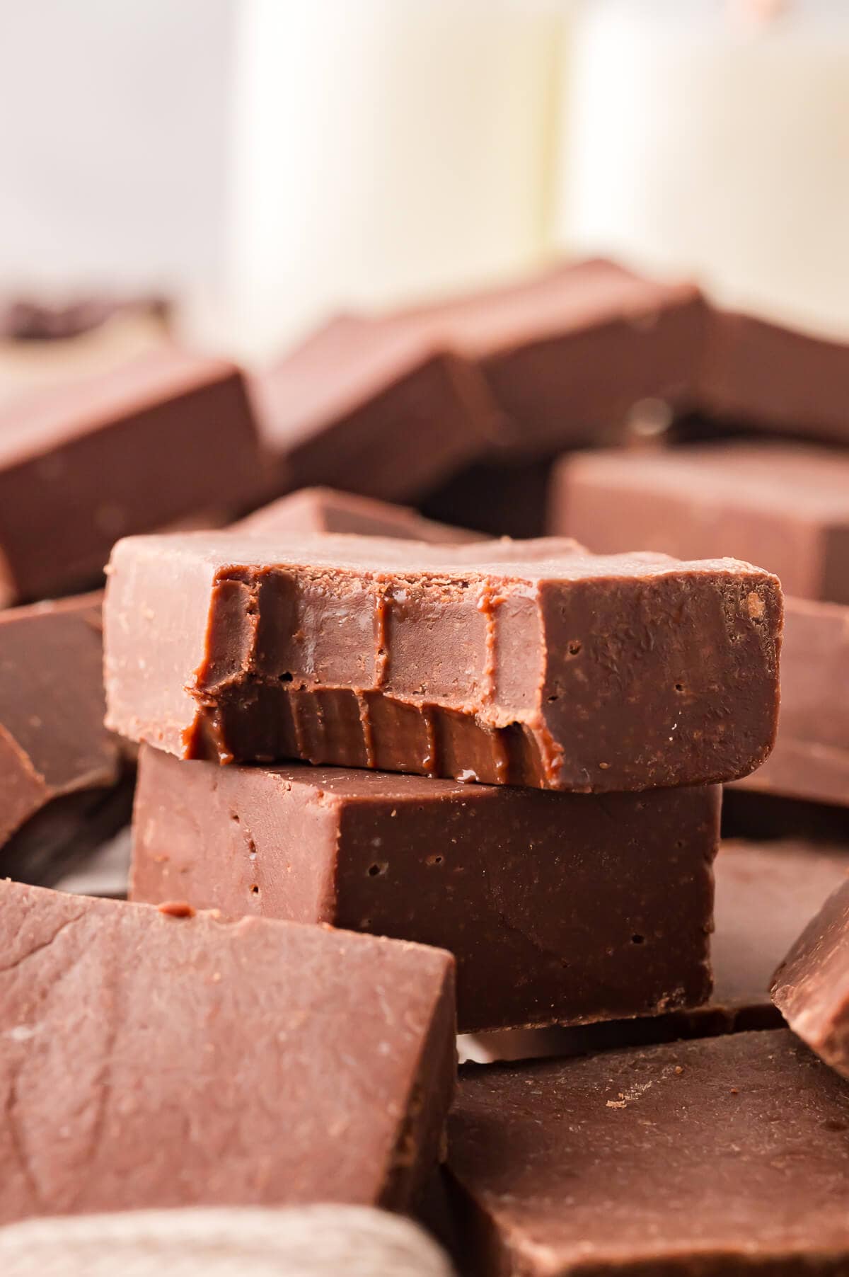 No-fail chocolate fudge with a bite out of one.