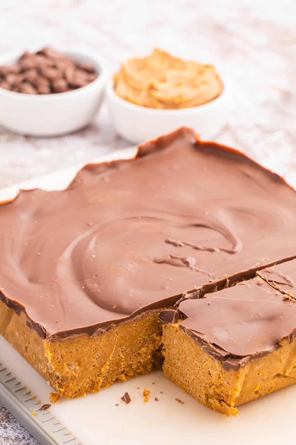 Peanut butter bars with a piece cut out of the main slab.