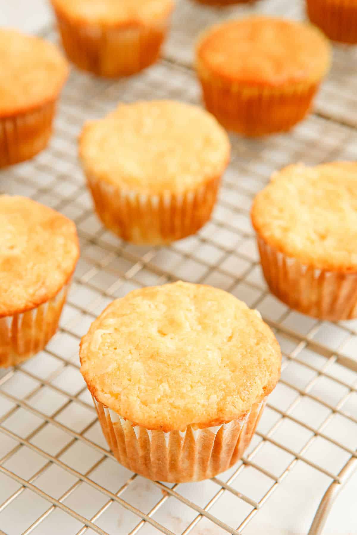 Pina colada muffins on a wire rack.