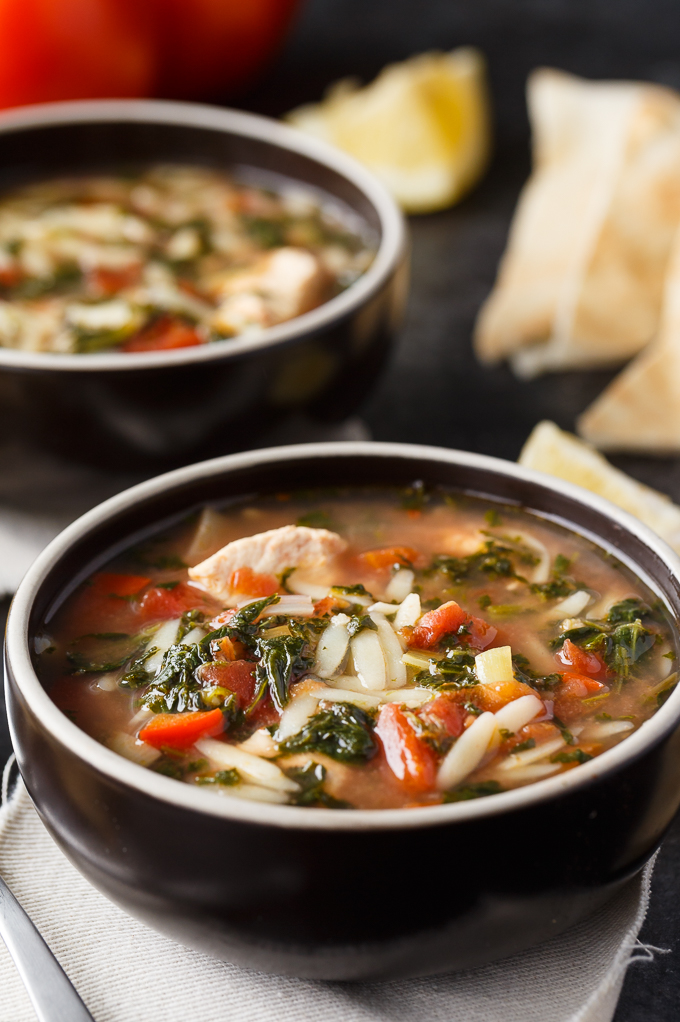 Greek Chicken Orzo Soup - A super comforting Crockpot soup! Enjoy this twist on homemade chicken noodle soup with tender orzo, red peppers, dill, spinach, tomatoes, and a dash of cinnamon. Yum!