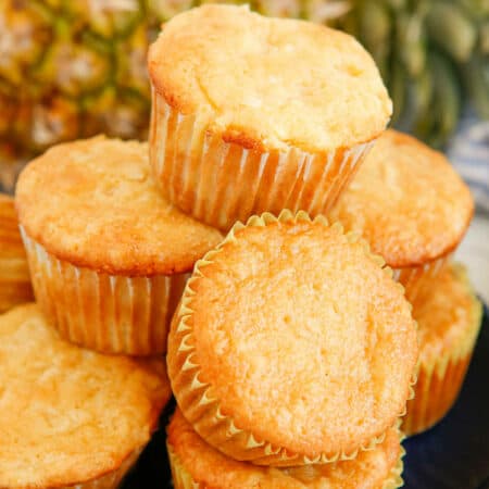 Pina colada muffins stacked on a plate.