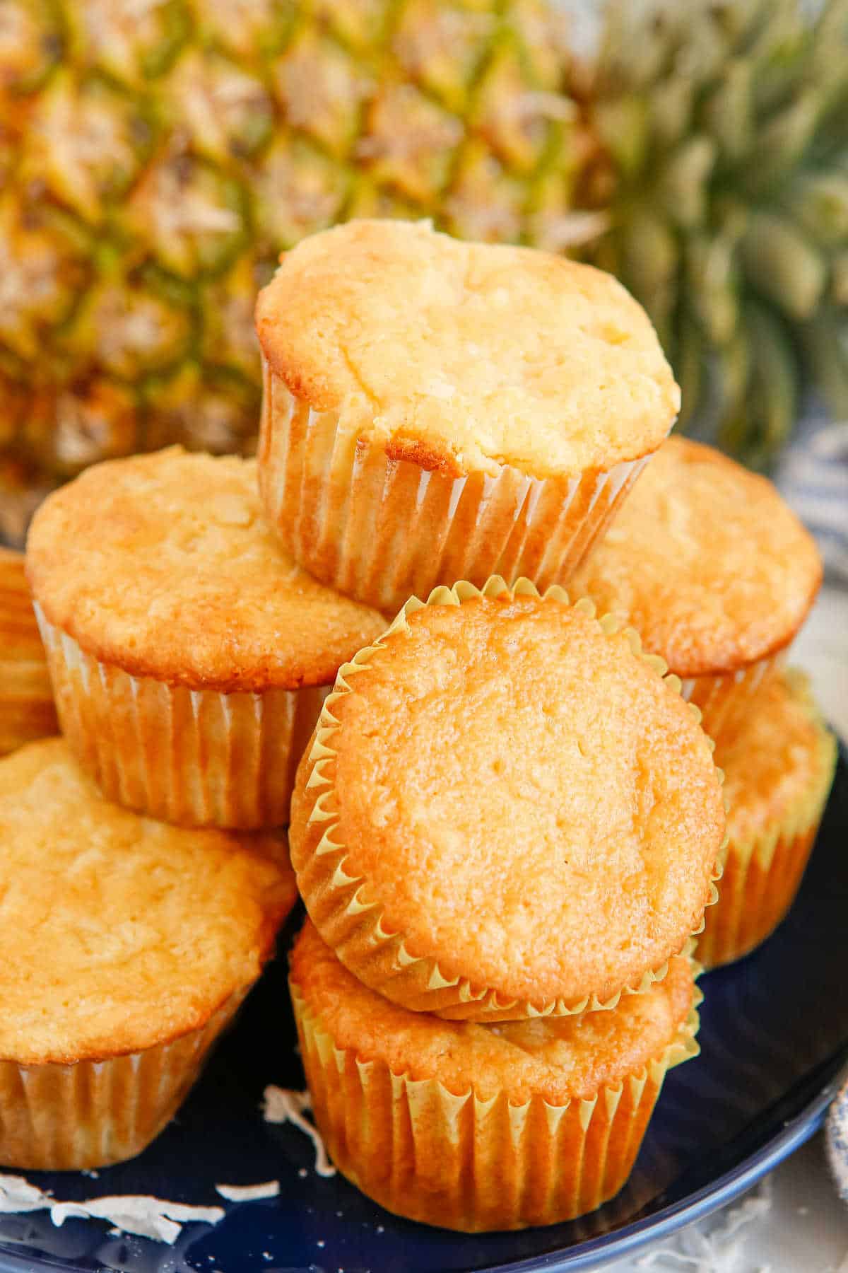 Pina colada muffins stacked on a plate.
