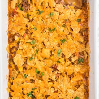 Beef Nacho Bake - This beefy nacho casserole is a welcome change from the traditional Taco Night. It hits all the right notes with cheese, beef, salsa and crunchy tortilla chips.