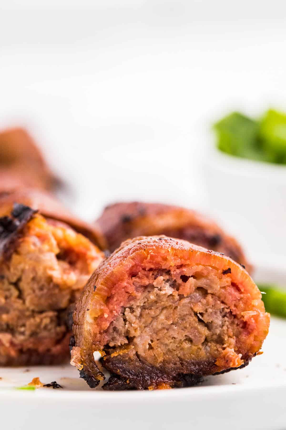 Stuffed Bacon Rolls cut in half on a plate.