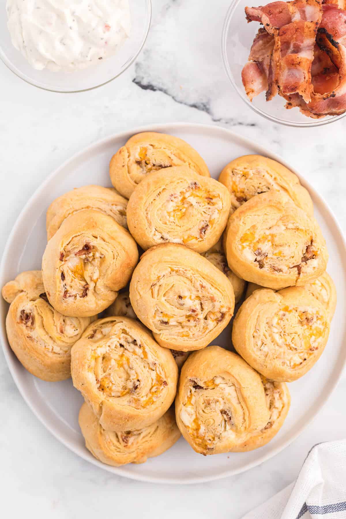 Cheesy Bacon Pinwheels - A dreamy holiday appetizer! Fluffy crescent rolls stuffed with bacon, onion, and two cheeses for a snack that's enough for a meal.