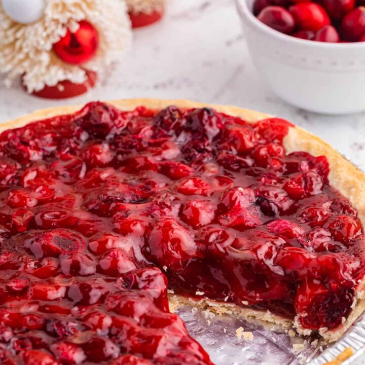 Cherry cranberry pie with a slice cut out.