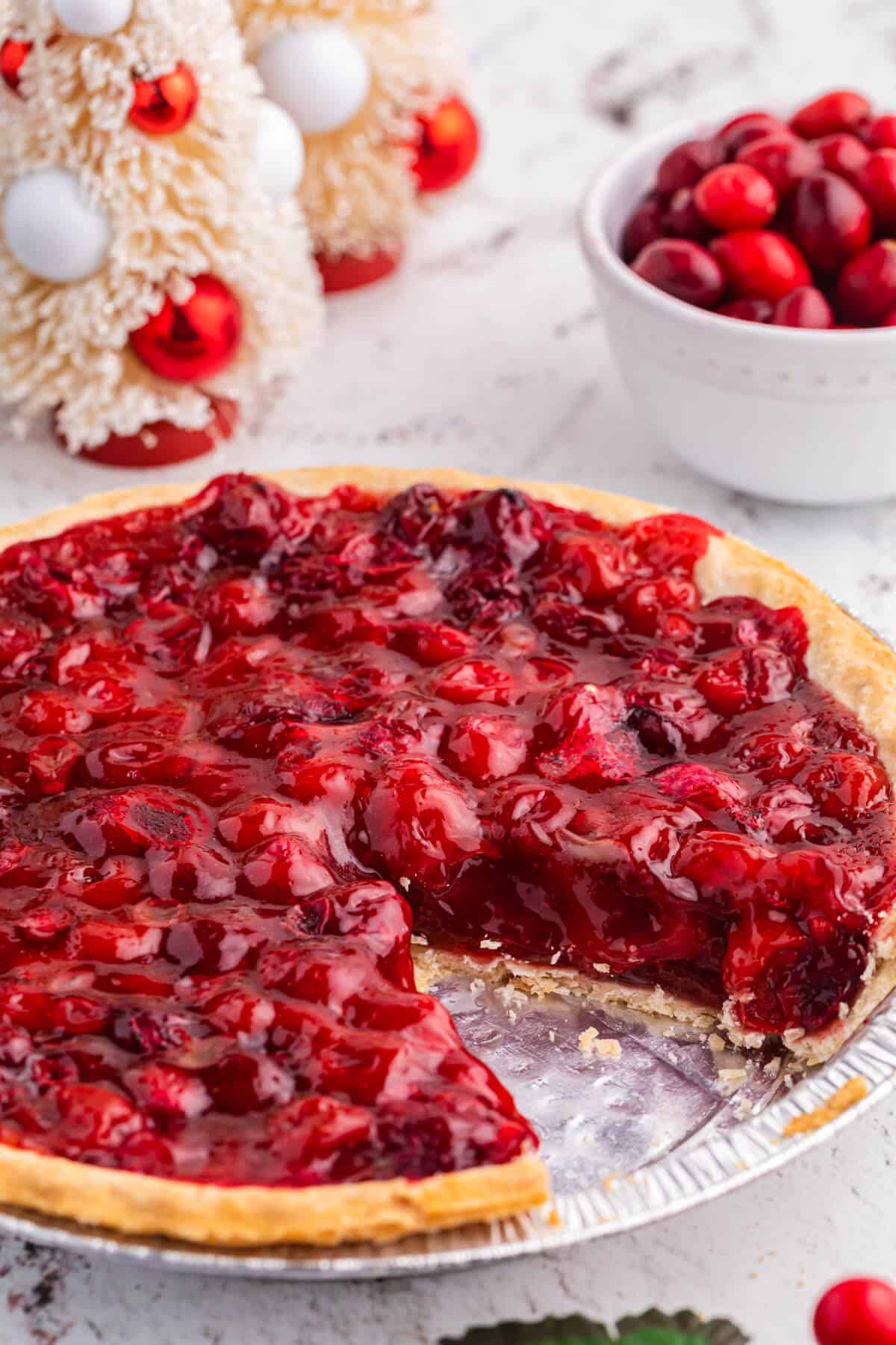 Cherry cranberry pie with a slice cut out.