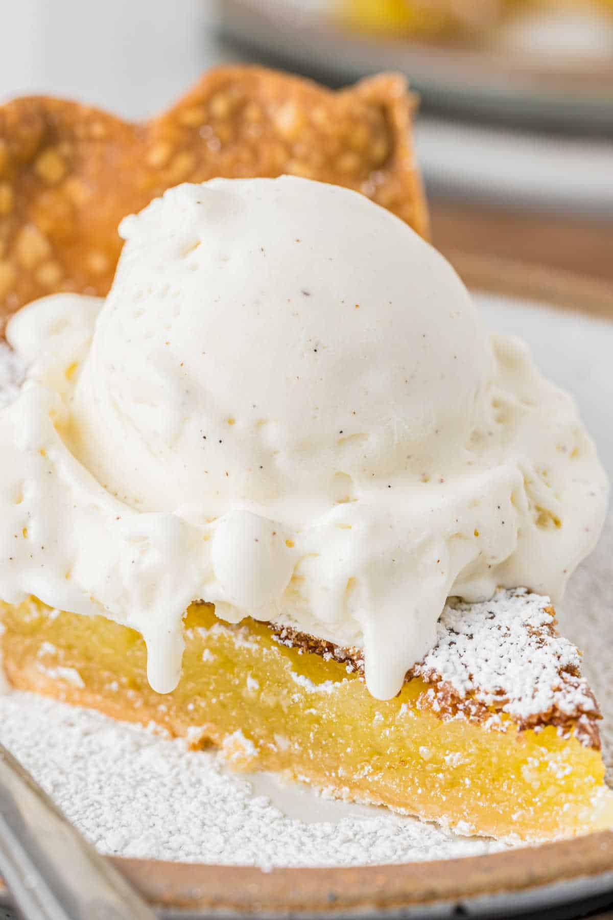 A slice of chess pie topped with ice cream.