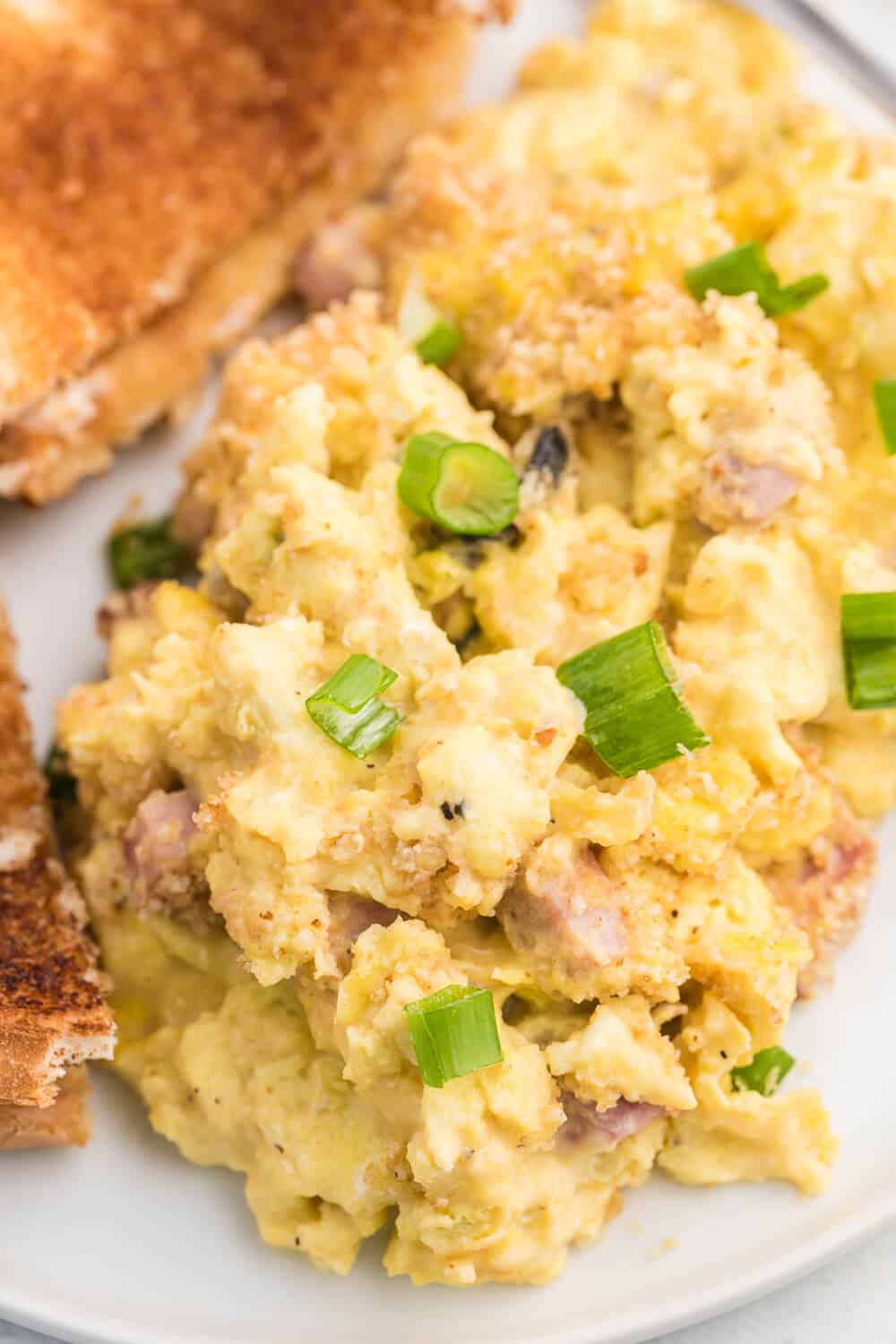 Scrambled Egg Casserole - Soft oven-scrambled eggs with ham, green onion, cheddar and mushrooms are baked under a crispy, toasted layer of bread crumbs. A delicious and decadent change from bread-based breakfast casseroles.