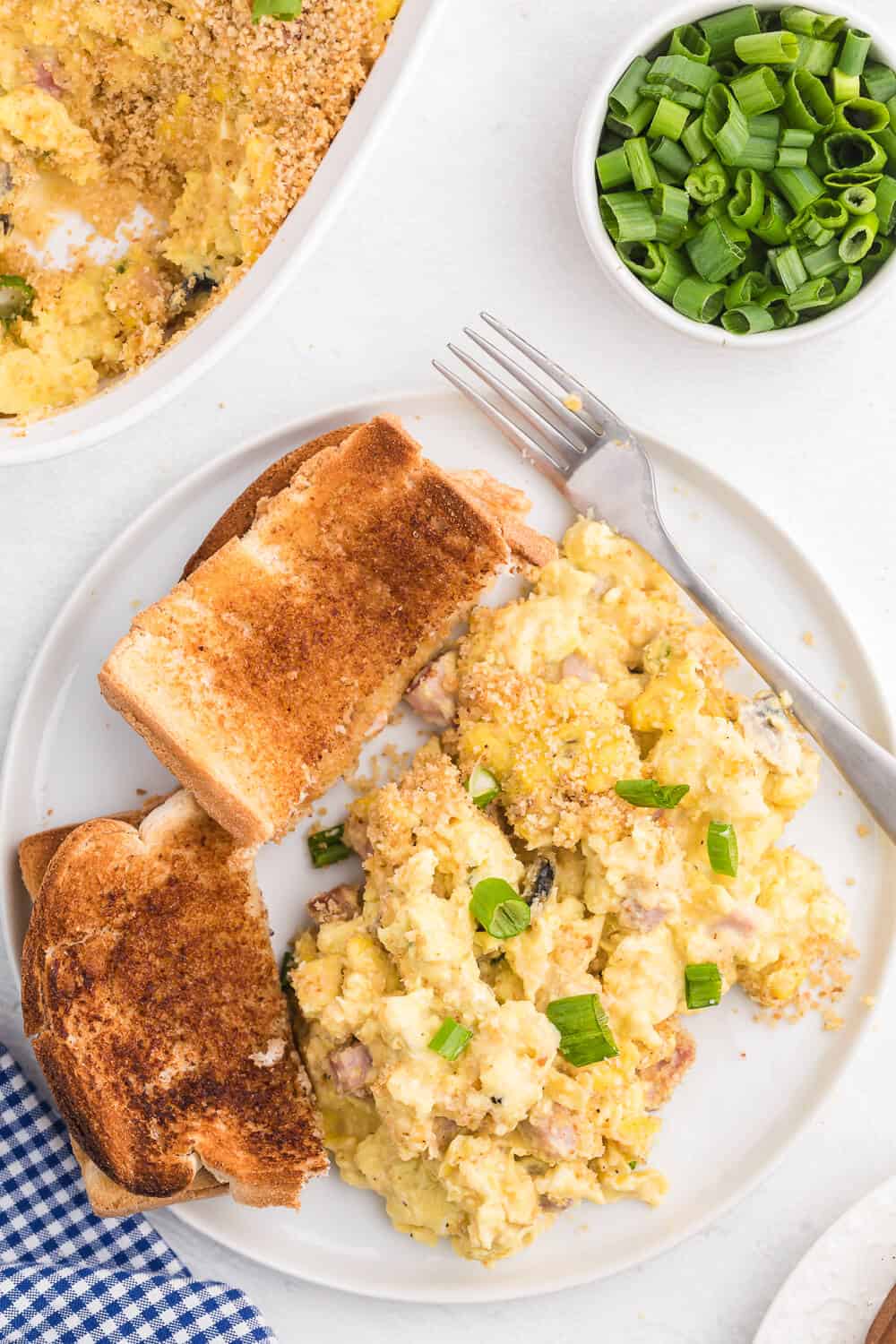 Scrambled Egg Casserole - Soft oven-scrambled eggs with ham, green onion, cheddar and mushrooms are baked under a crispy, toasted layer of bread crumbs. A delicious and decadent change from bread-based breakfast casseroles.