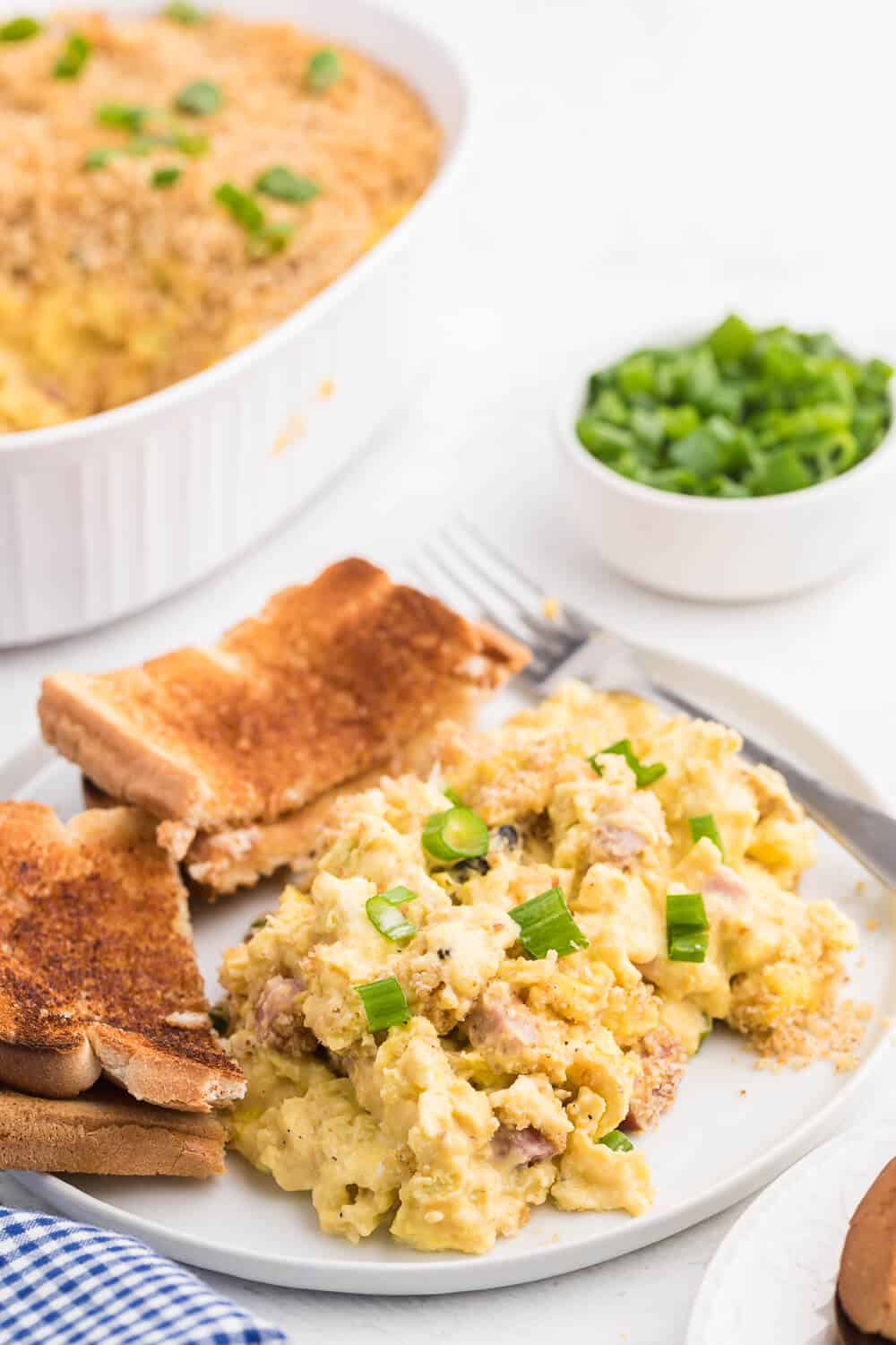 Scrambled Egg Casserole - Soft oven-scrambled eggs with ham, green onion, cheddar and mushrooms are baked under a crispy, toasted layer of bread crumbs. A delicious and decadent change from bread-based breakfast casseroles.