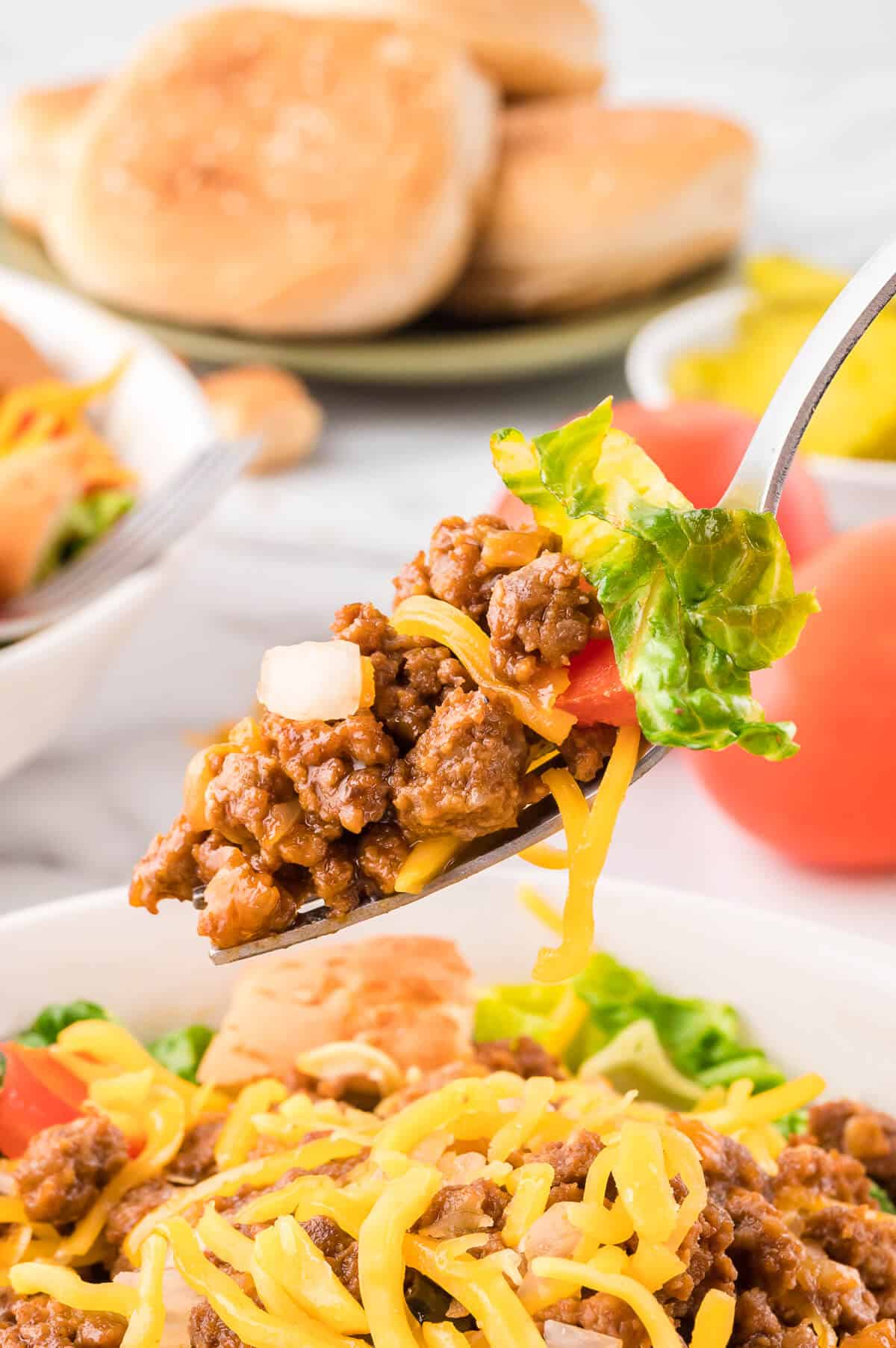 A fork with cheeseburger salad on it.