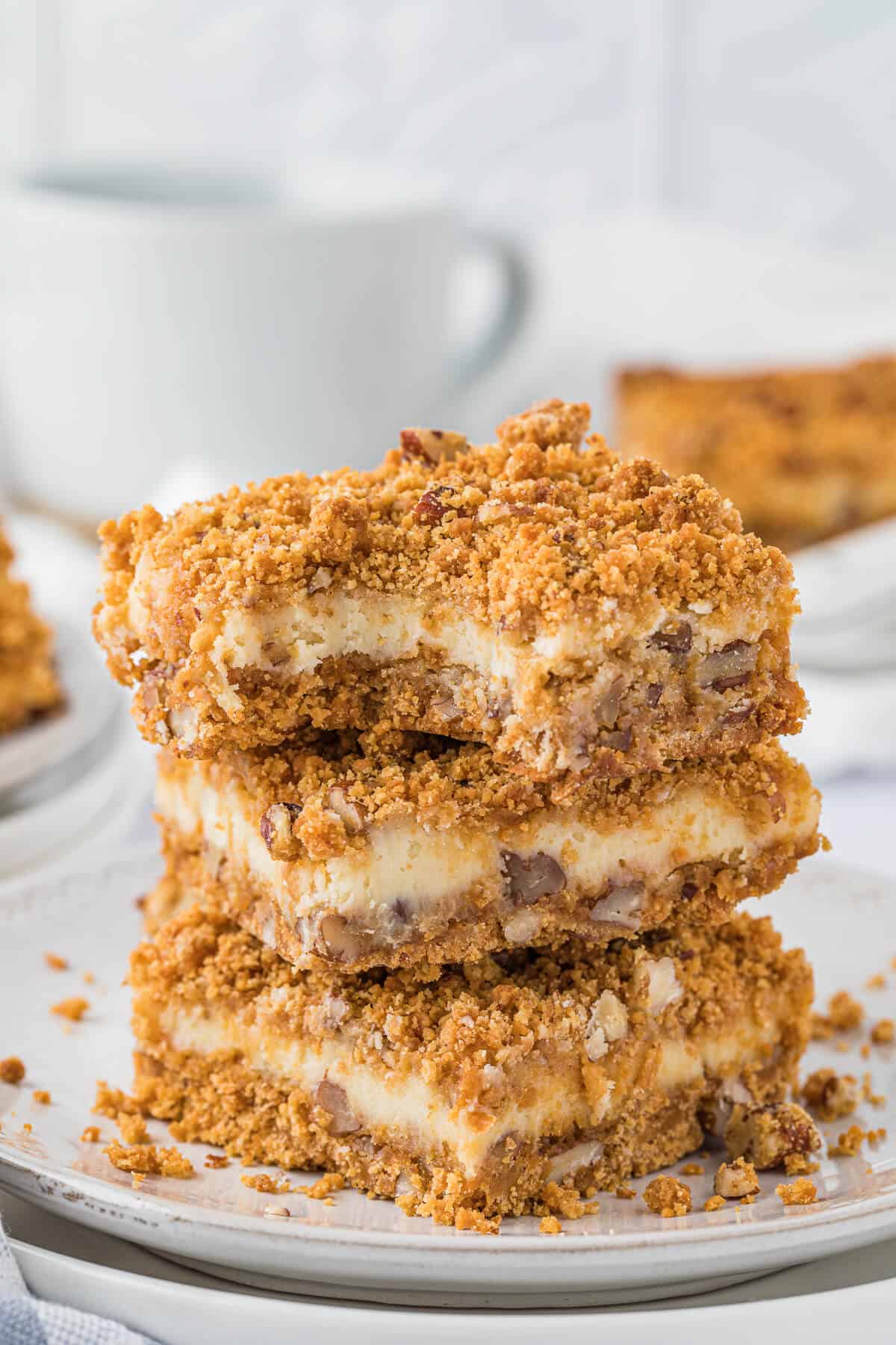 A stack of butterscotch cheesecake bars on a plate.