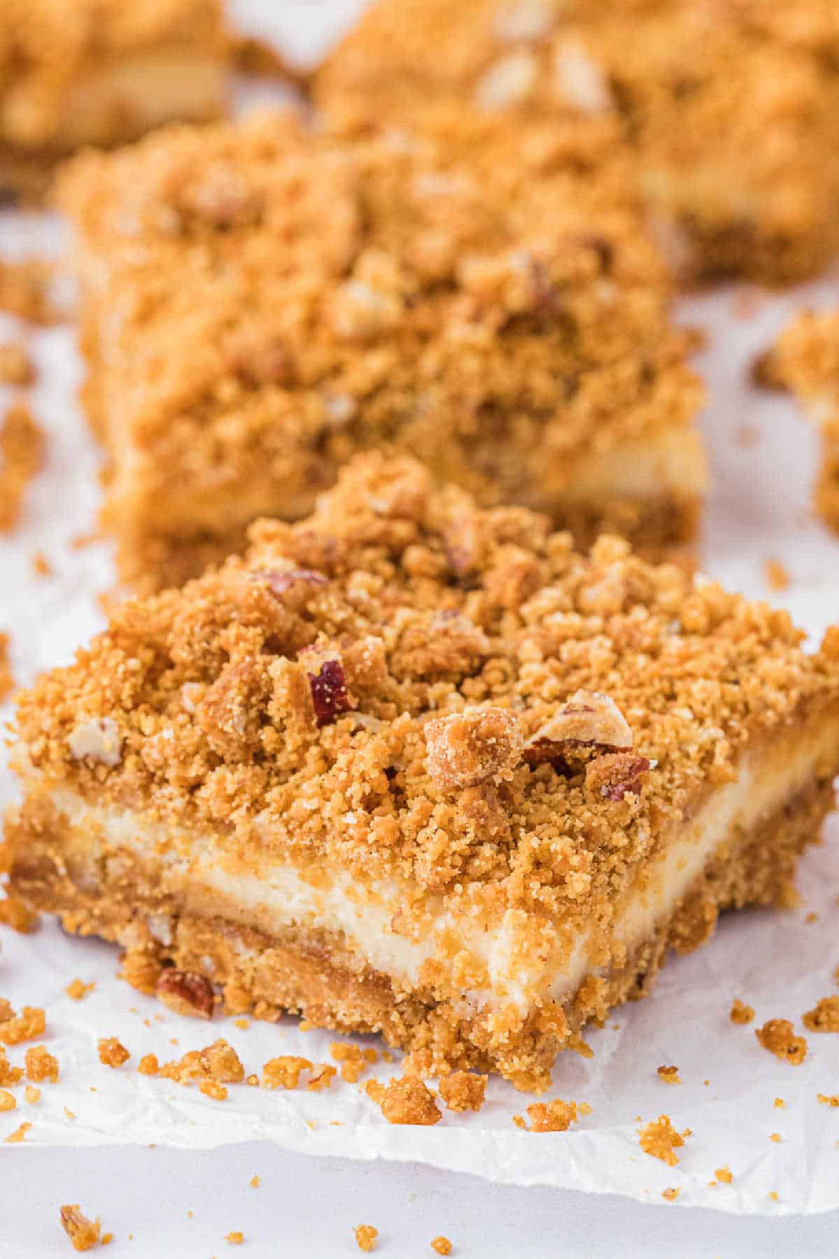 Butterscotch cheesecake bars on a piece of parchment paper.