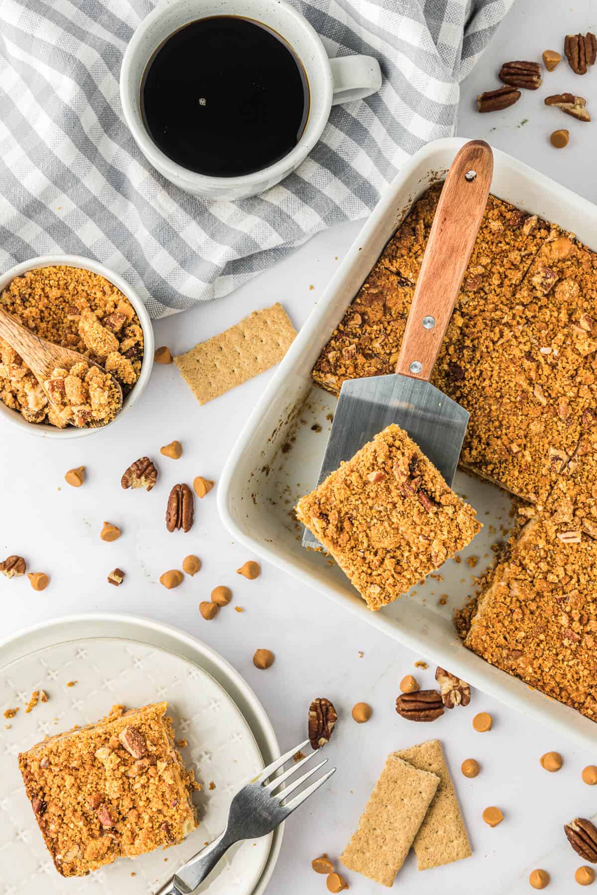 Butterscotch Cheesecake Bars served in a pan with a spatula.