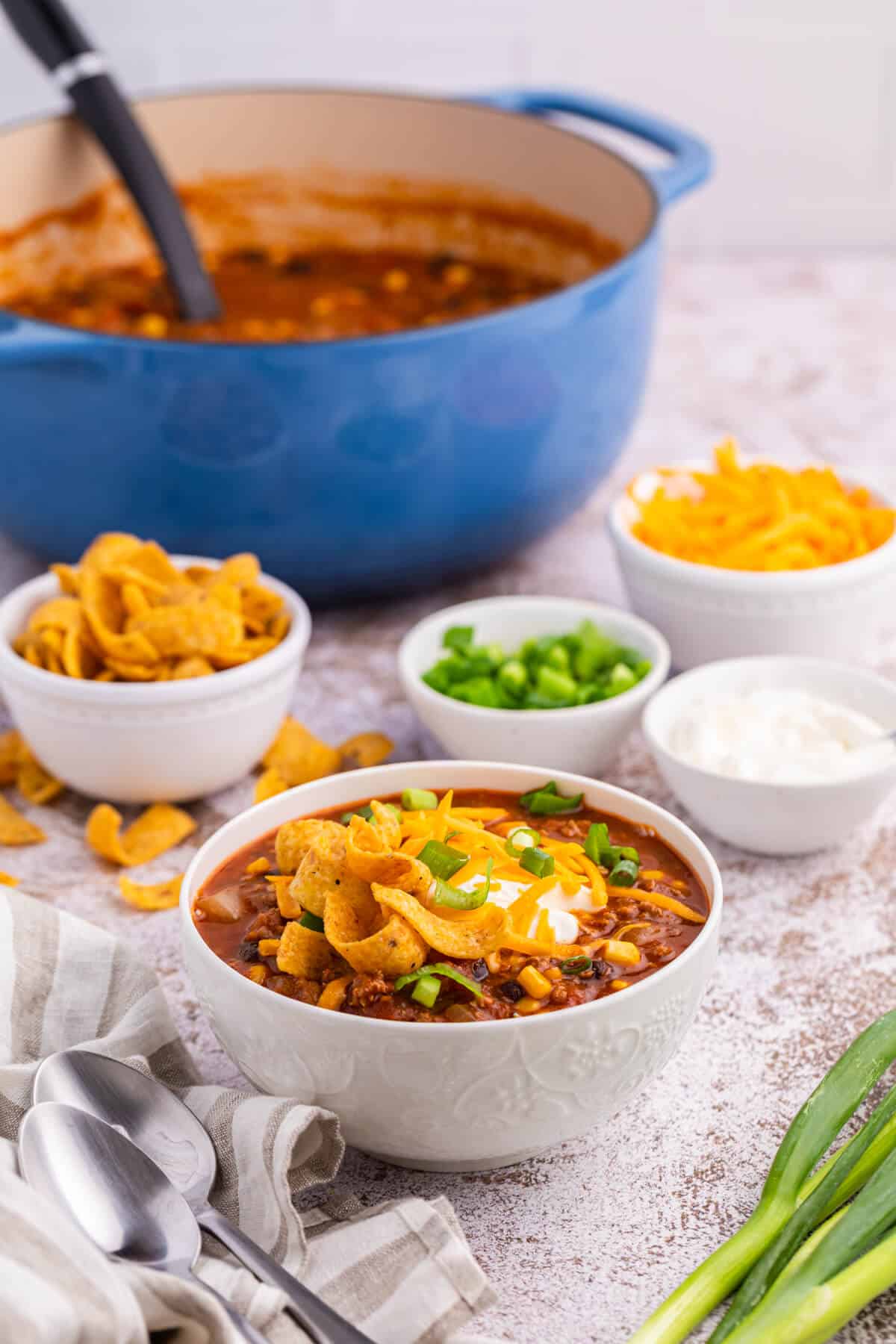 Taco chili in a white bowl with toppings.