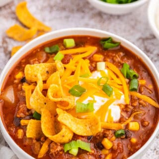 Taco chili in a white bowl with toppings.