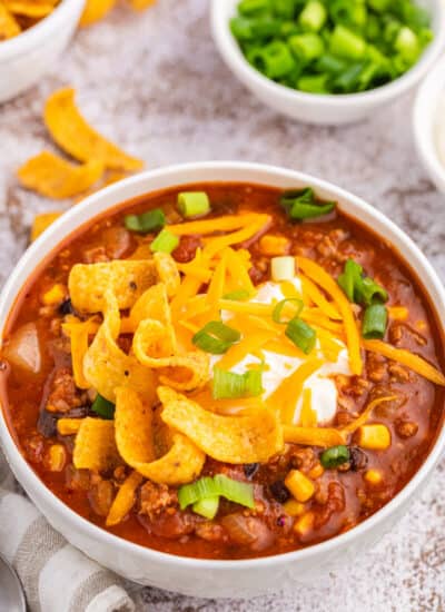 Taco chili in a white bowl with toppings.