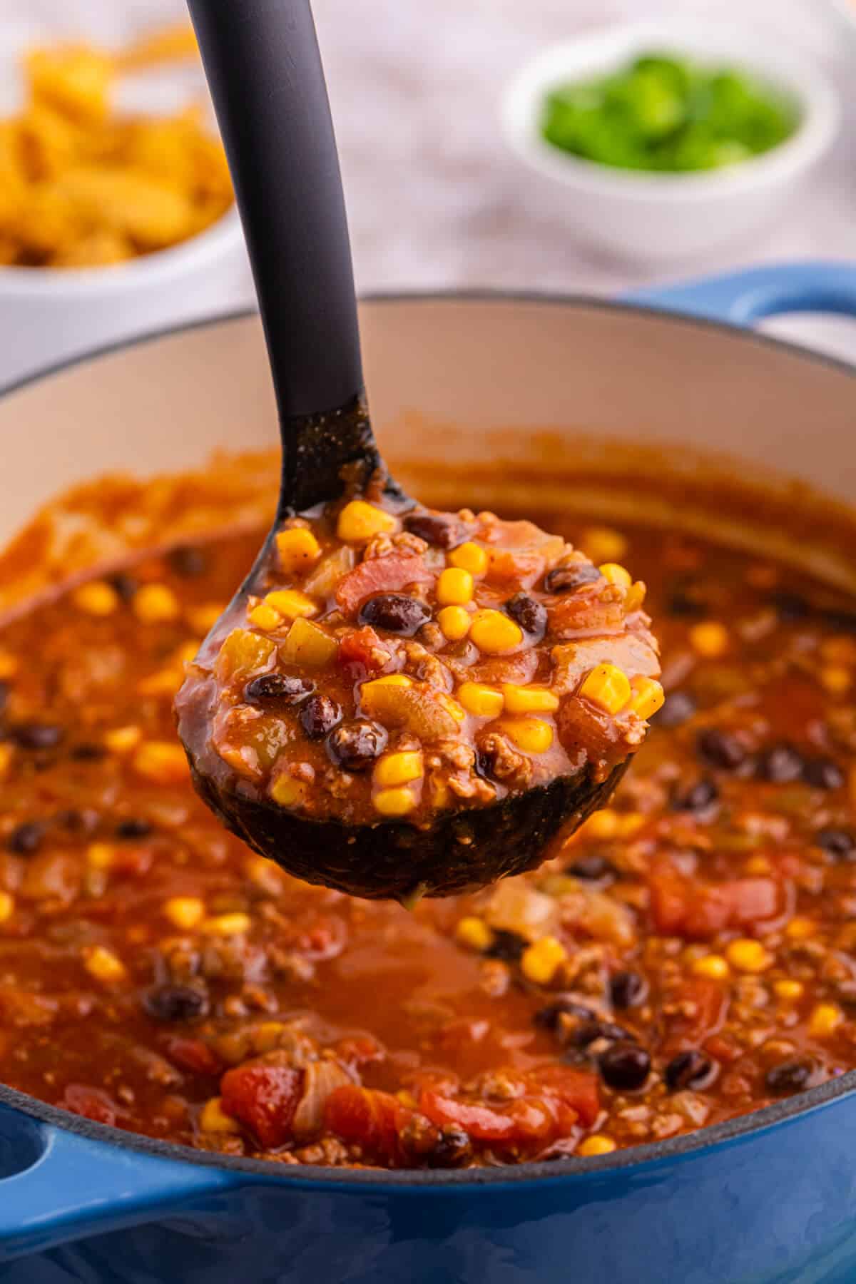 Taco chili in a black ladle over a pot.