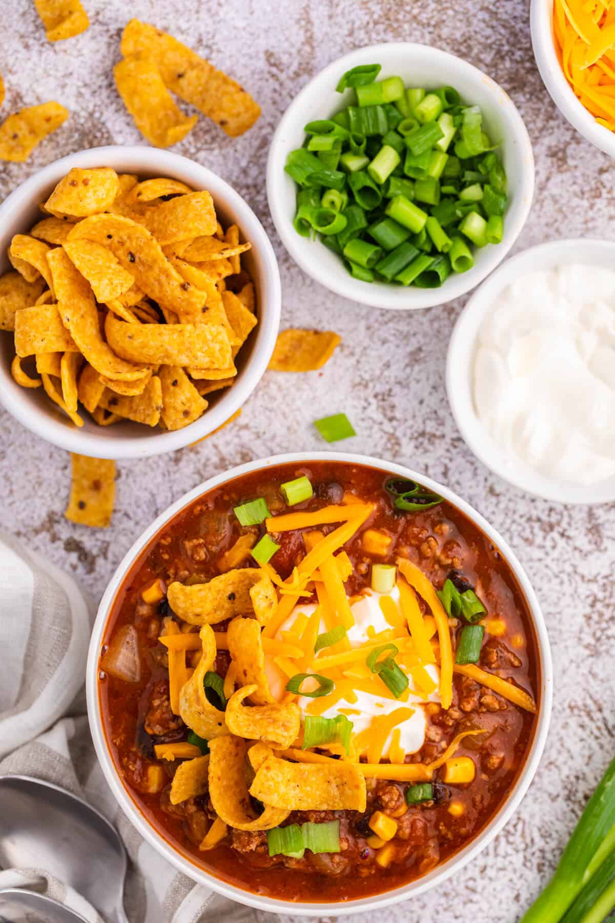 Taco chili in a white bowl with toppings.
