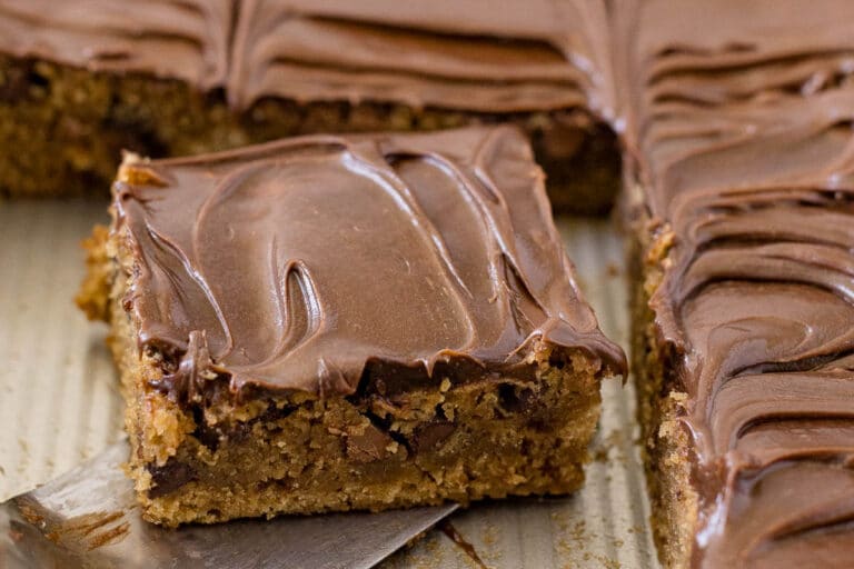 A slice of mocha cake on a spatula in a pan.