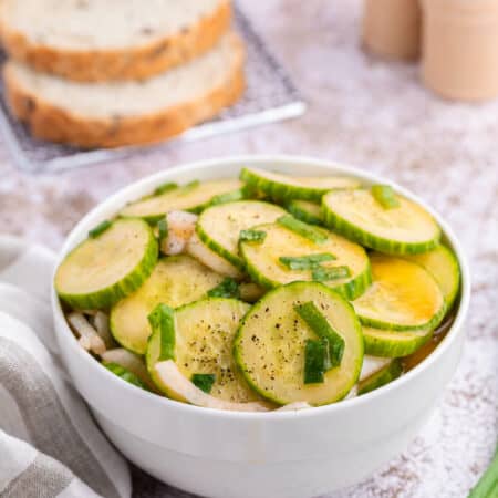 Cucumber salad in a white bowl.