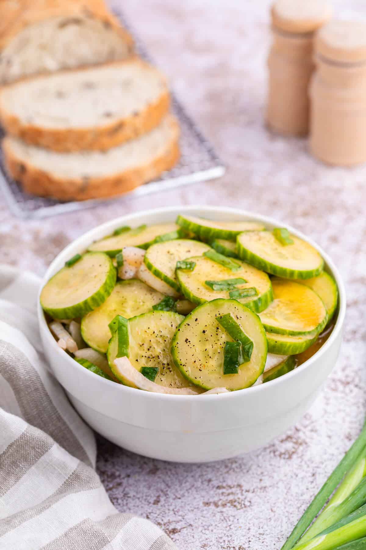 Cucumber salad in a white bowl.